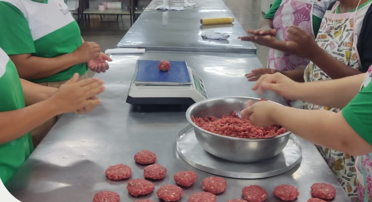 Pessoas preparando salgados em cozinha profissional